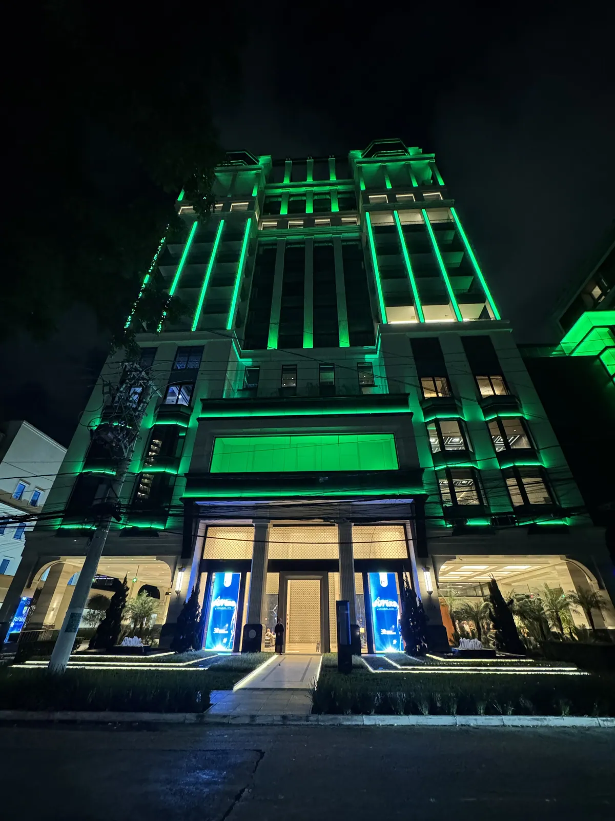 Fachada do edifício iluminada em verde à noite