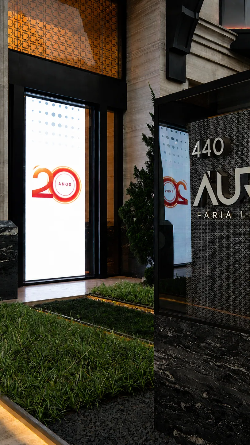 Totem de LED com a identidade do evento ao lado da placa do edifício